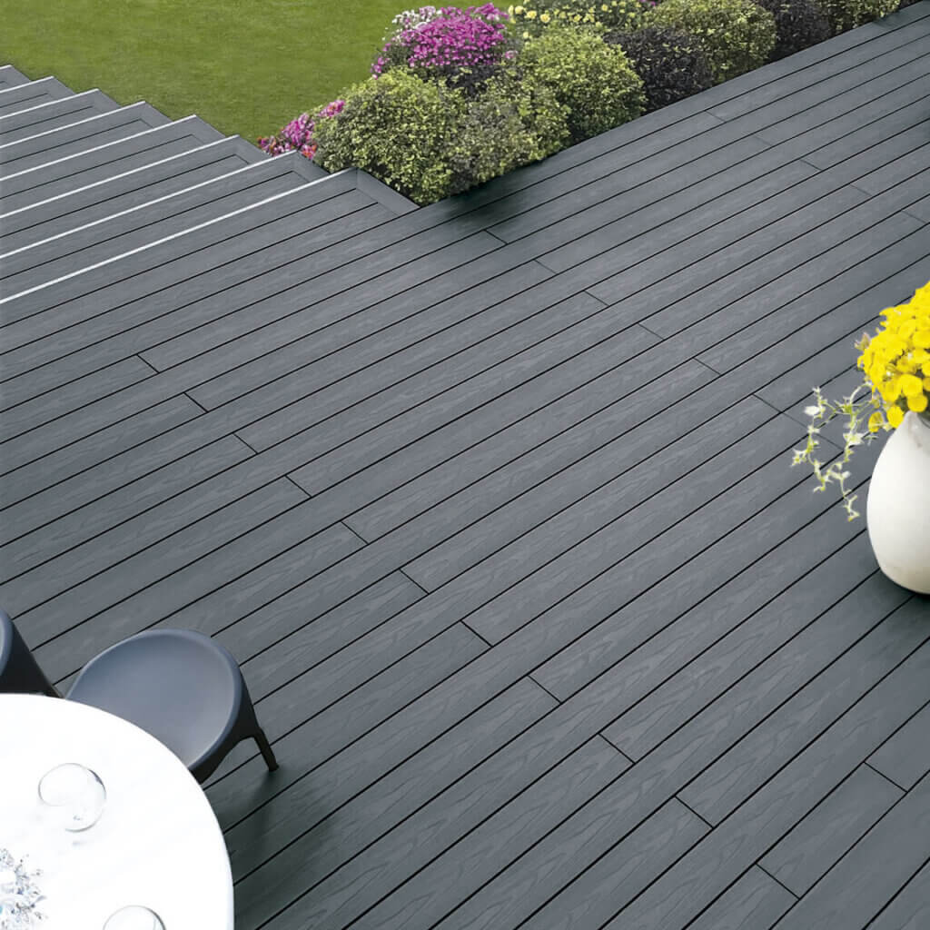 Dark gray composite decking near with grass and flowers