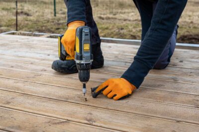 building holding a drill fixing up a deck