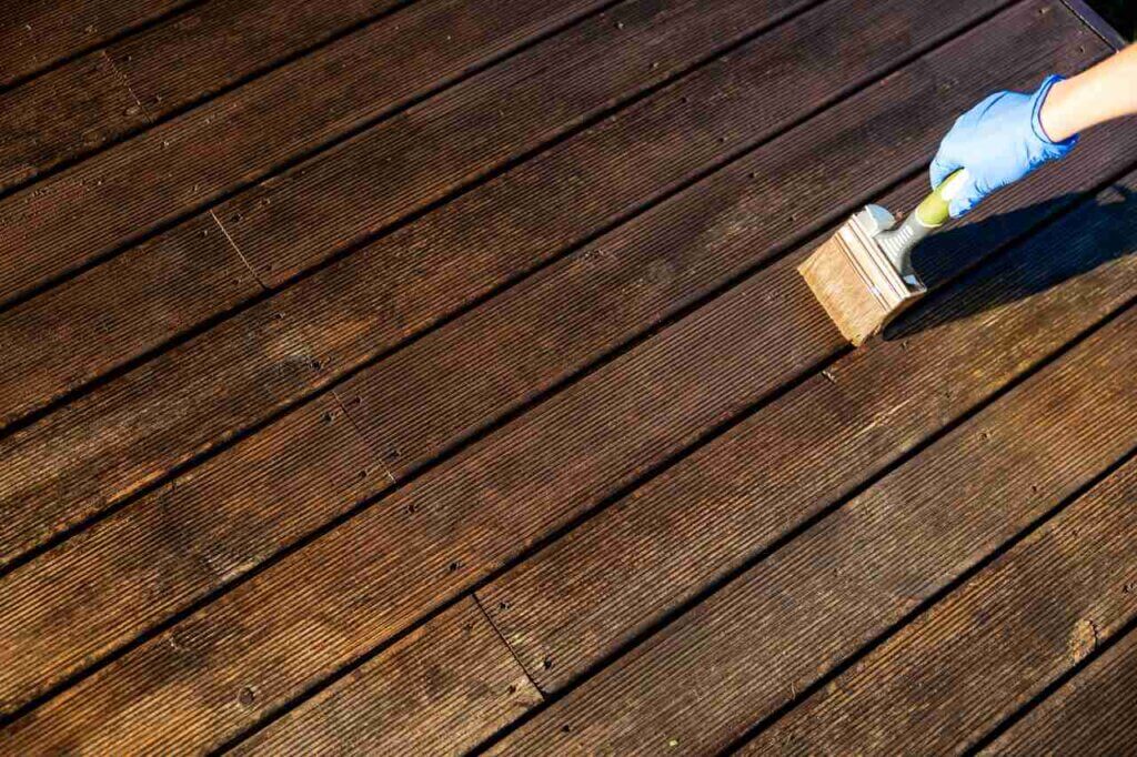 person brushing wooden deck