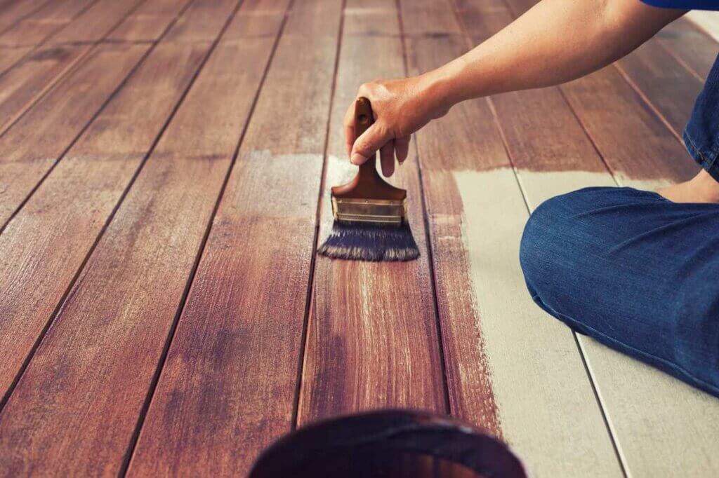 person staining a deck