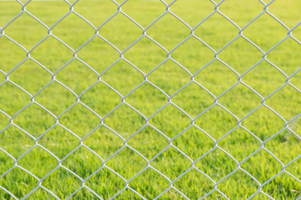 chain link fence with green grass on the background