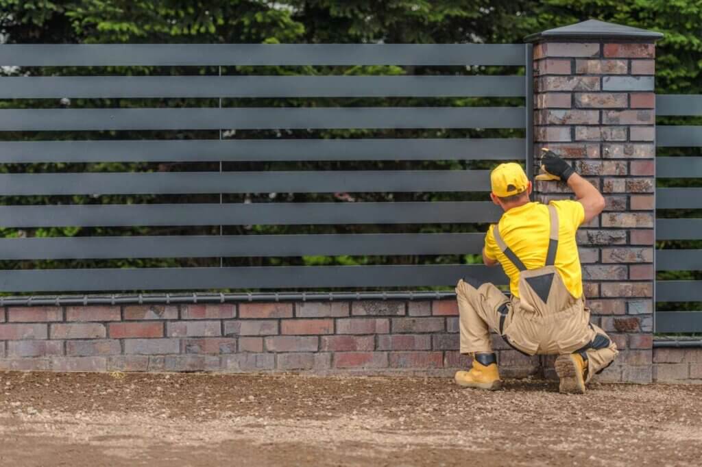 man working on building horizontal fence