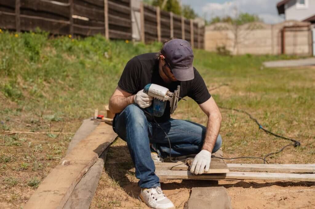 man building a wooden fence