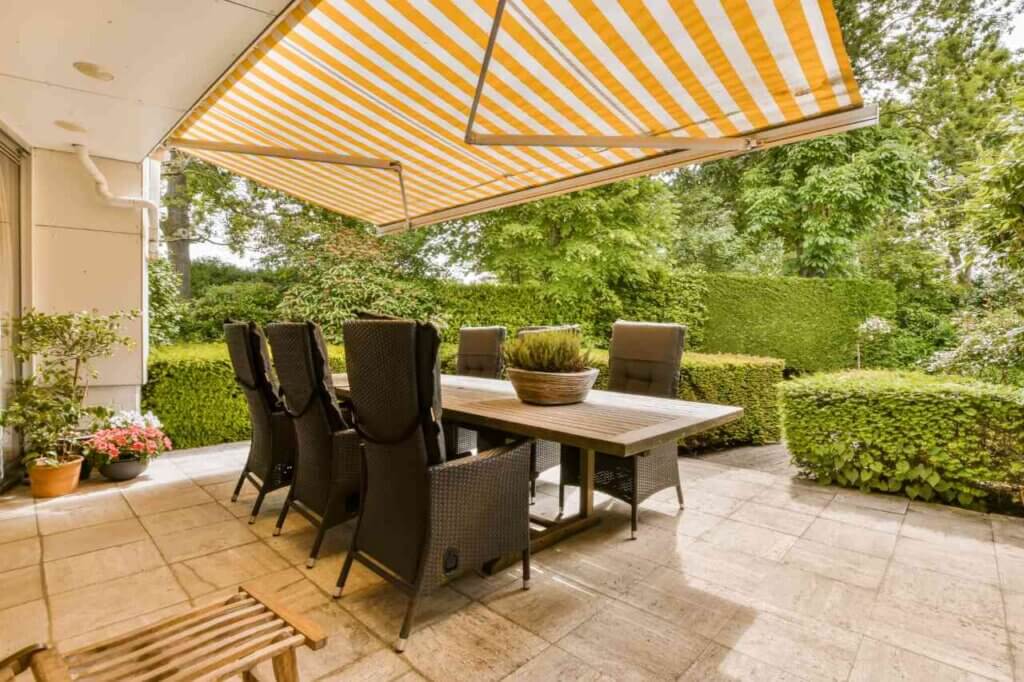 A patio with a table and chairs under an awning