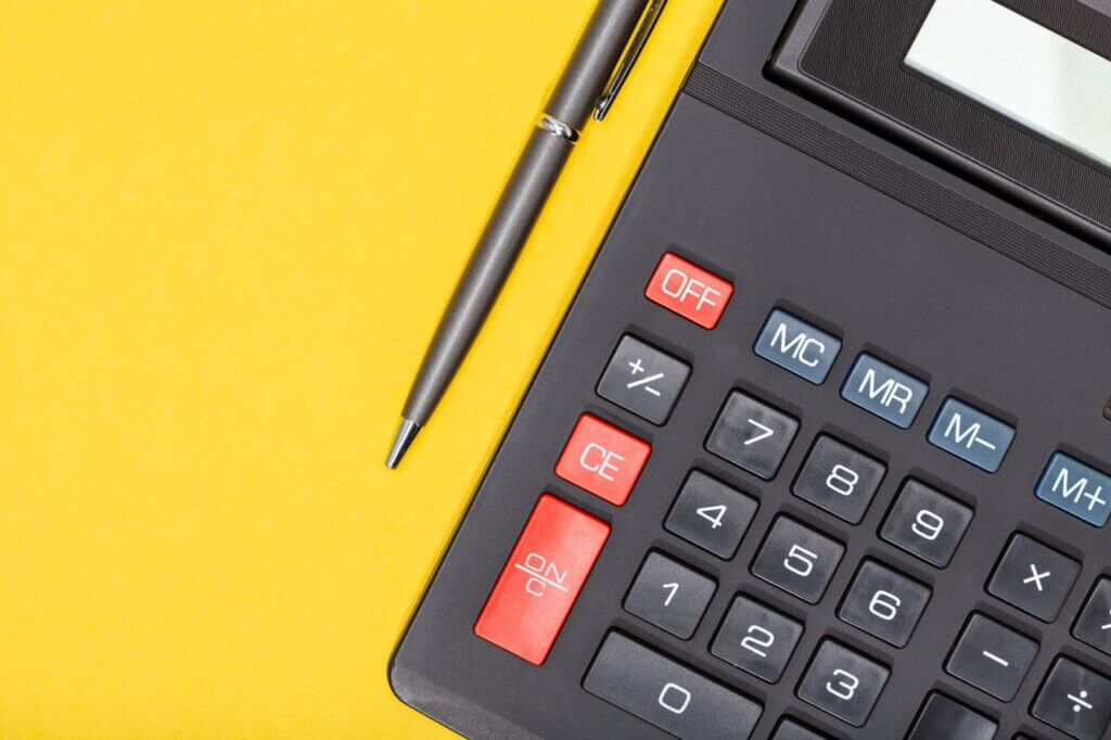 calculator and pen on a yellow background