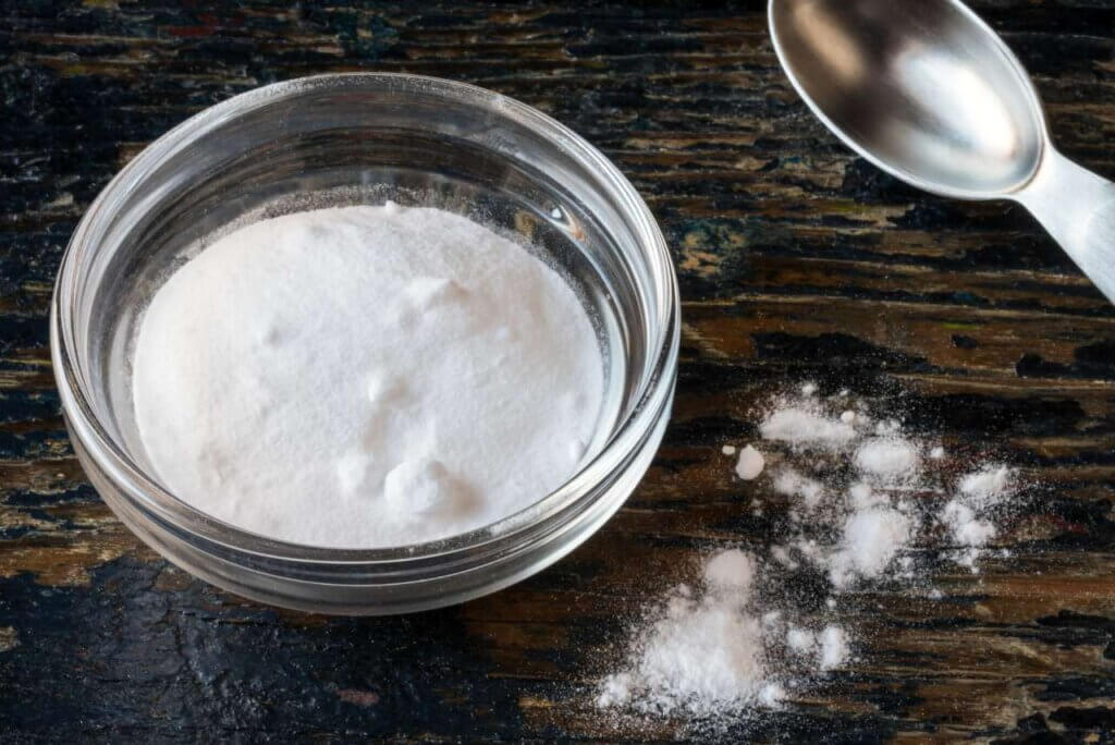 baking soda in a glass bowl and a spoon